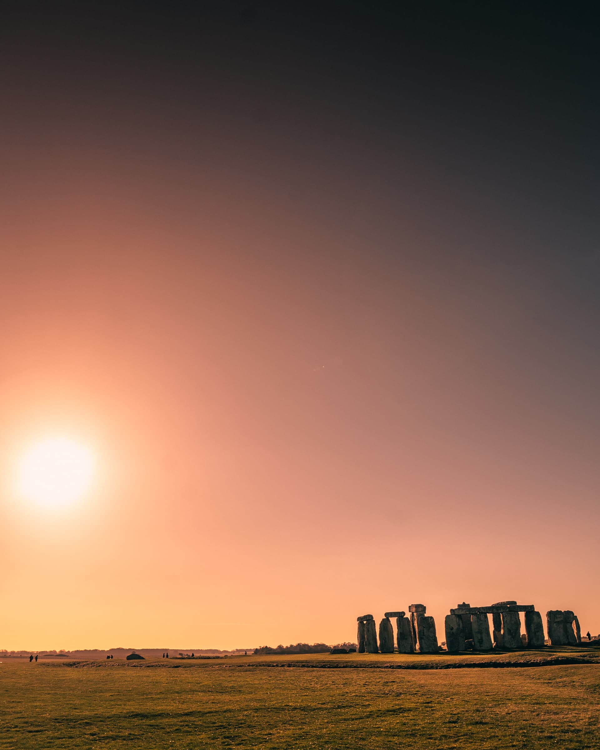 Stonehenge in silhouette against an orange sky