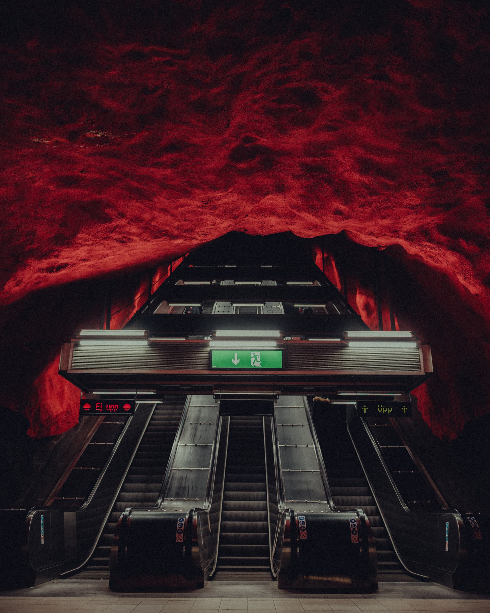 Escalators under the red rock ceiling of Solna centrum metro station, Stockholm