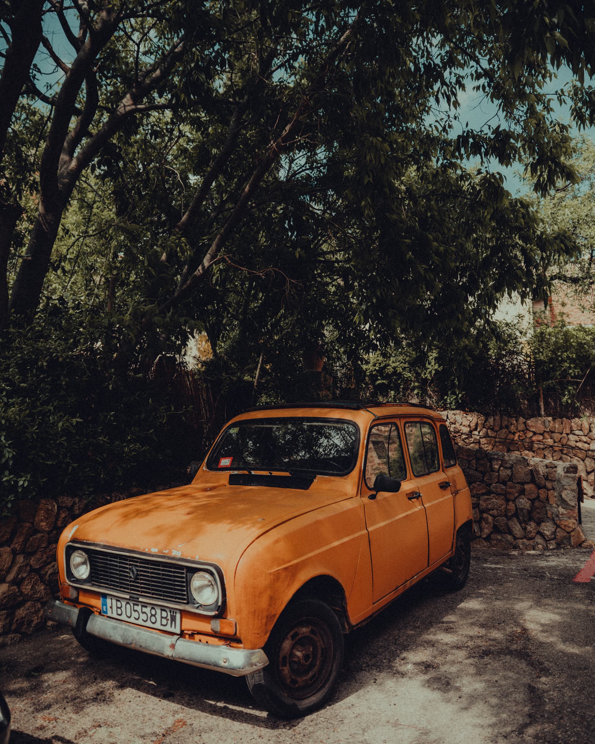 Orange Renault 4 parked on a leafy street in Palma, Majorca