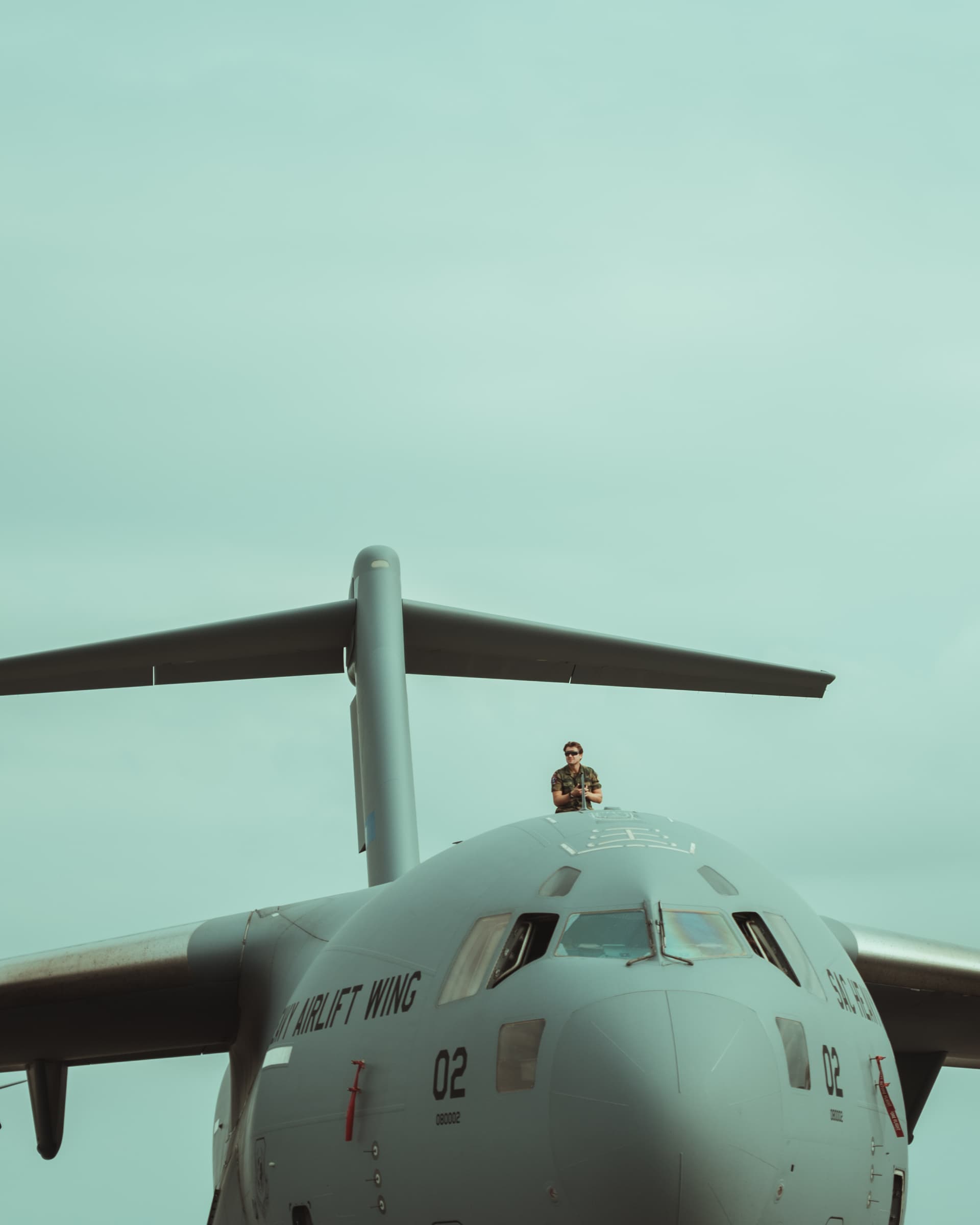 Grey military transport aircraft against a pale sky in Uppsala