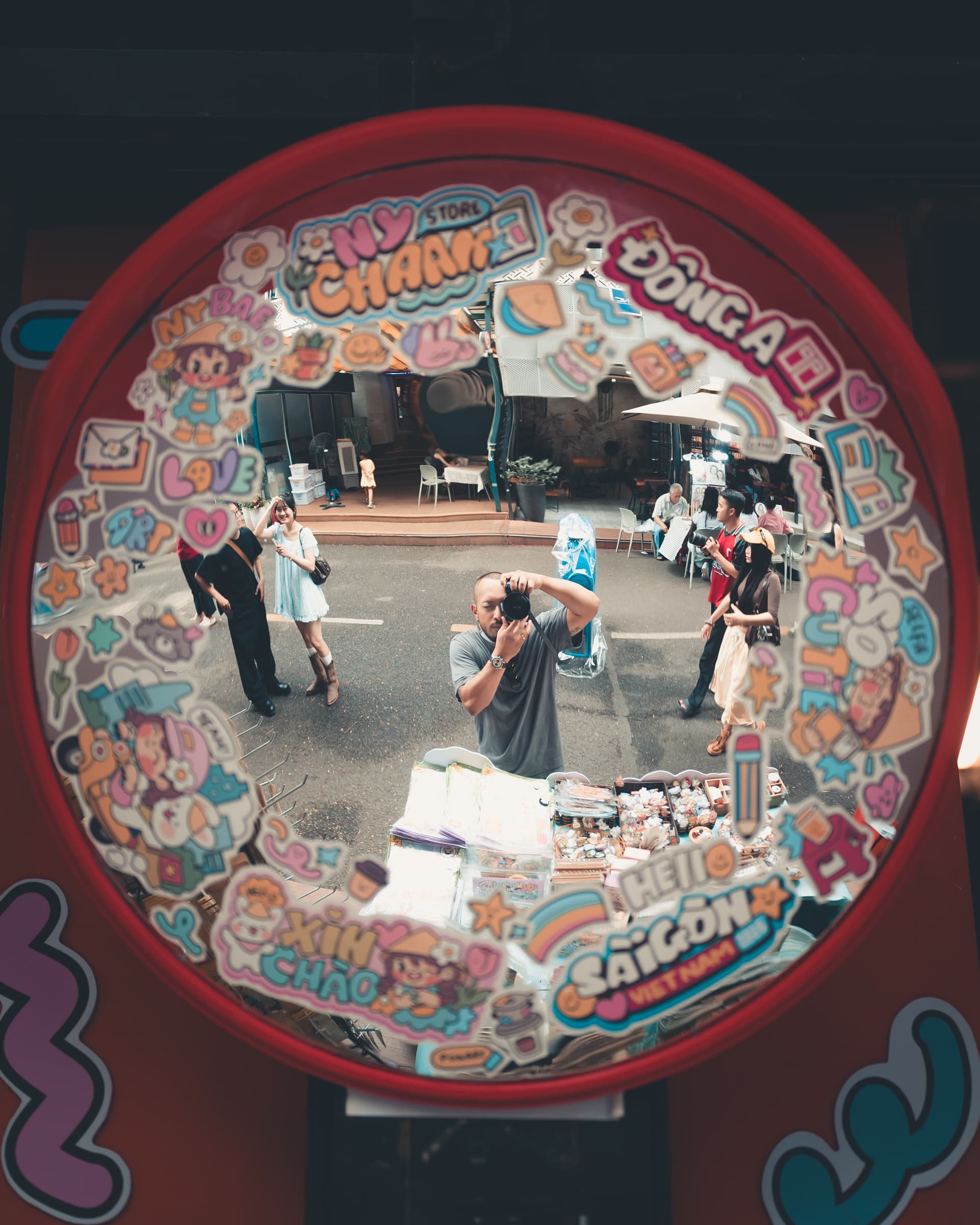 A street seen through a round window covered in stickers