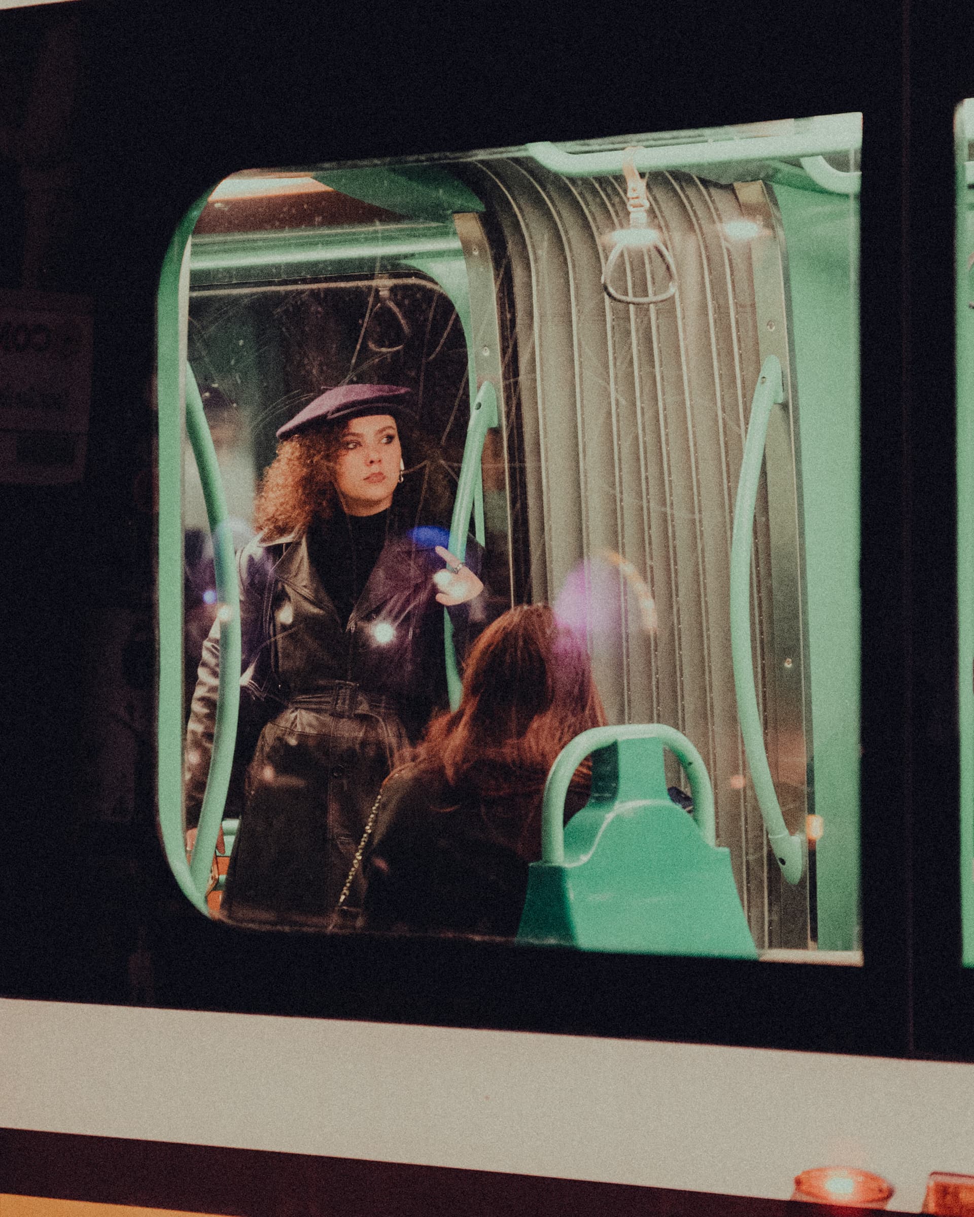 Woman in a beret seen through the window of a vintage tram