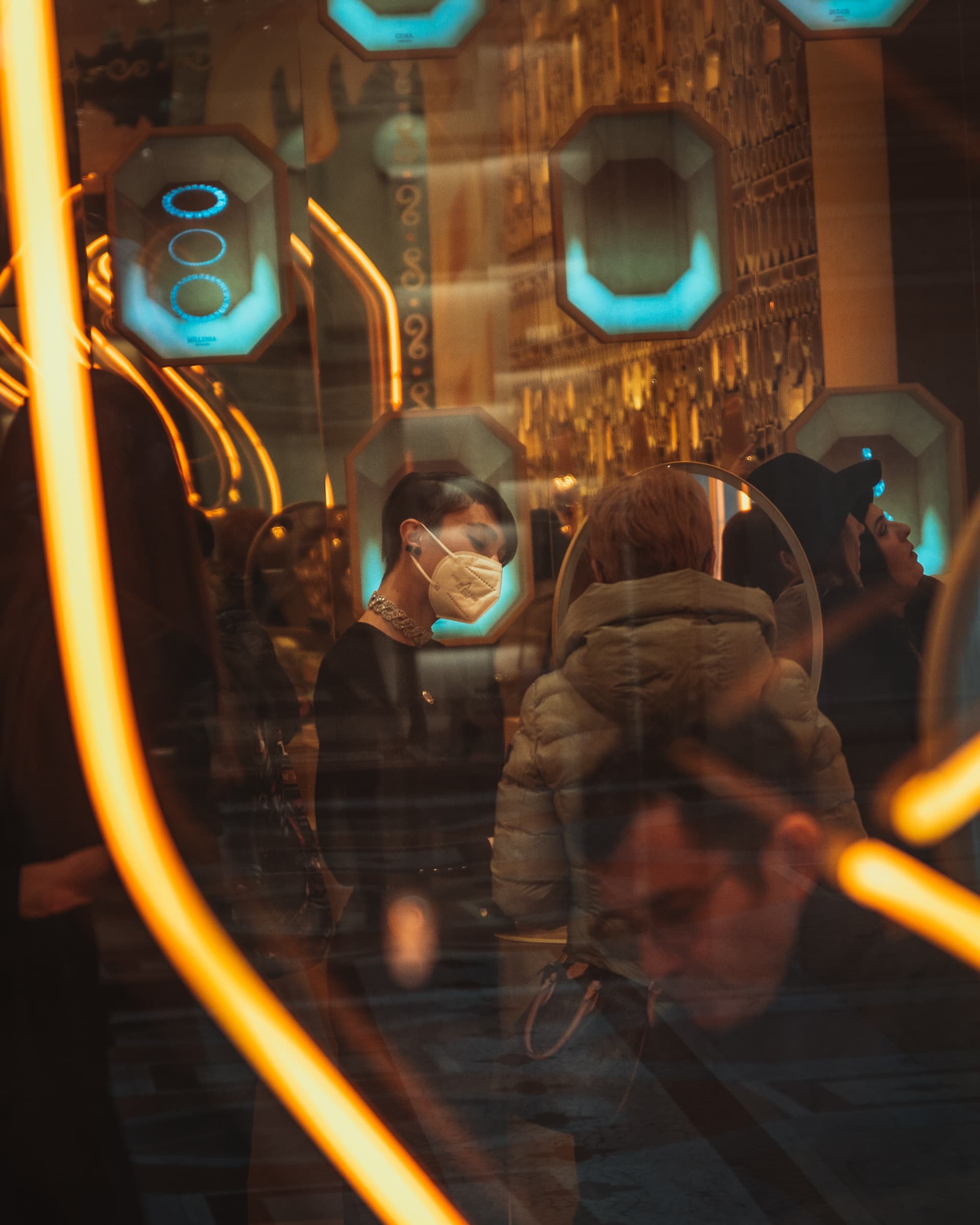 Passengers seen through glass streaked with orange and blue light