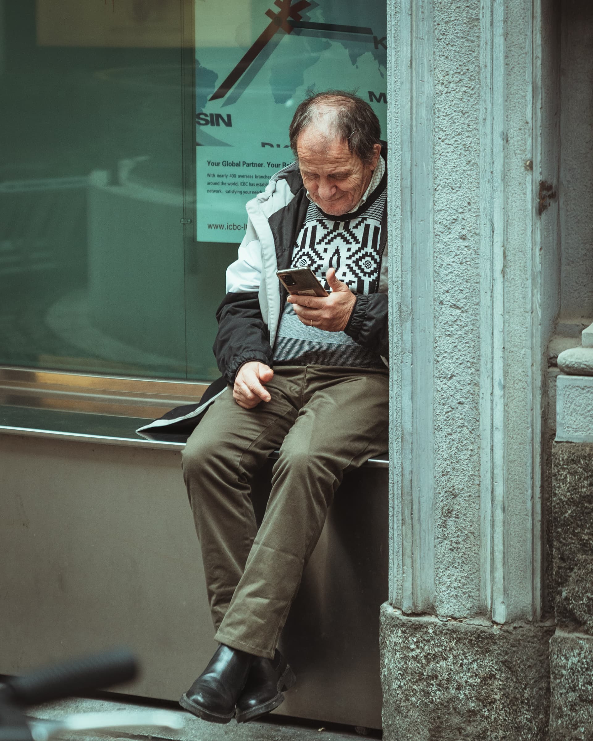 Man reading his phone in a stone doorway